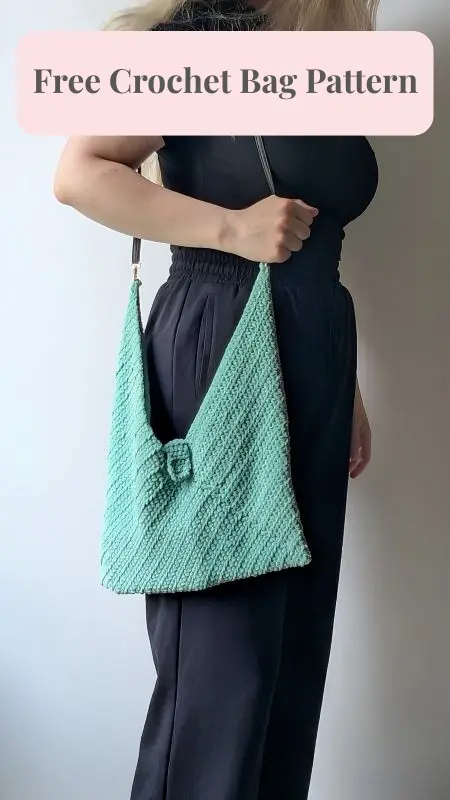 Mint crochet bag with unique texture and center clasp held by woman in black outfit.