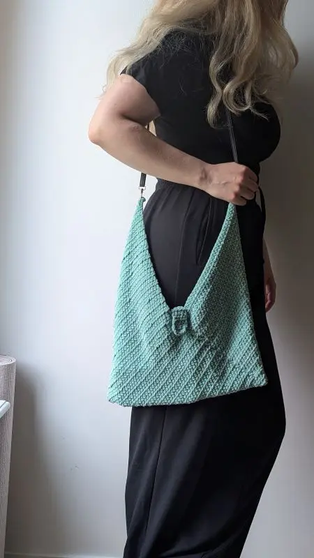 Crochet Bag - Free Pattern - Make it in 1 weekend Woman modeling a mint crochet bag with a modern texture and decorative clasp. Thre bag is crochet using the free crochet bag pattern in the article
