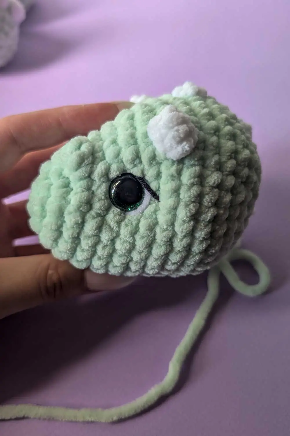 Crocheted dinosaur head in progress embroidery instructions