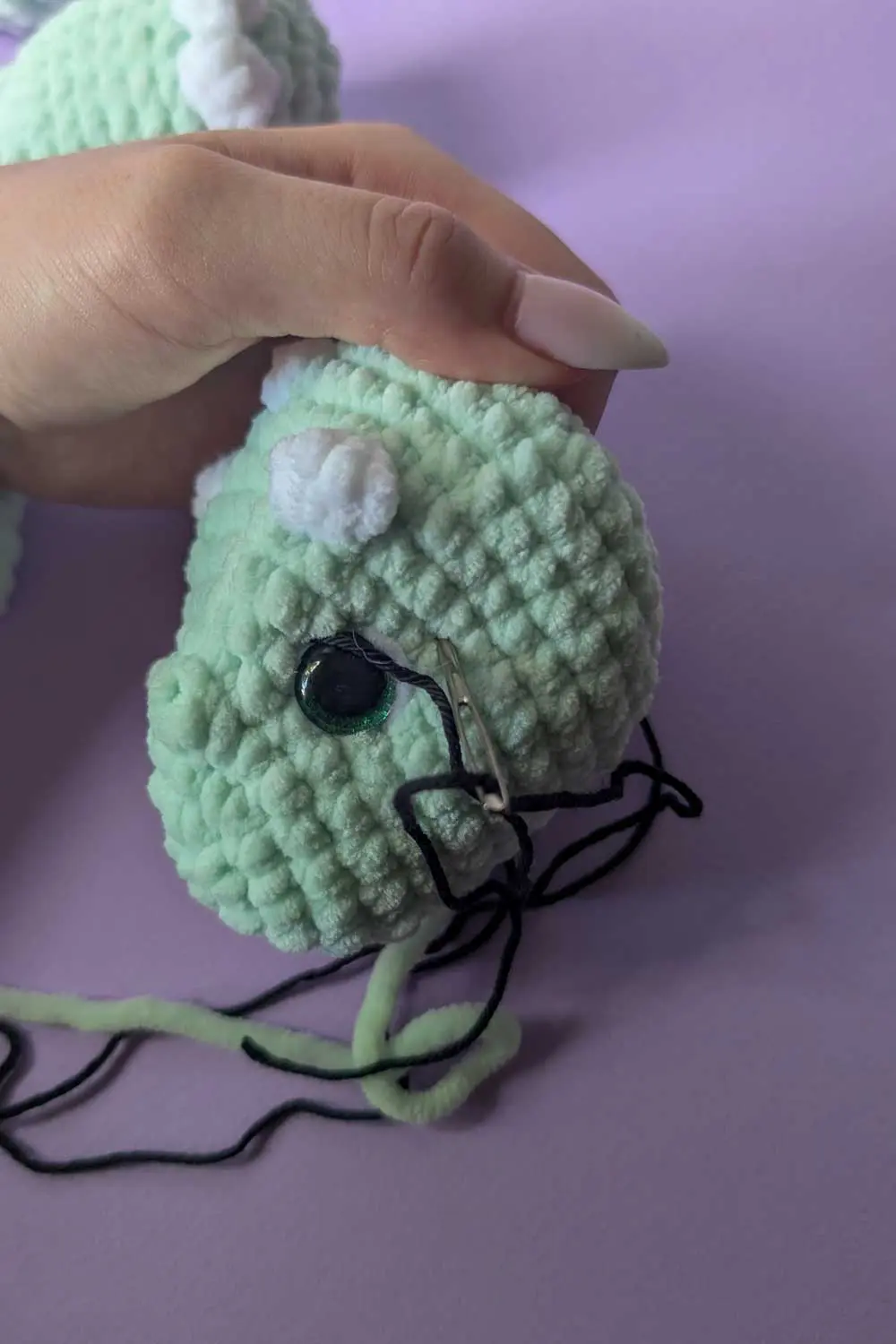 Crocheted dinosaur head in progress embroidery instructions