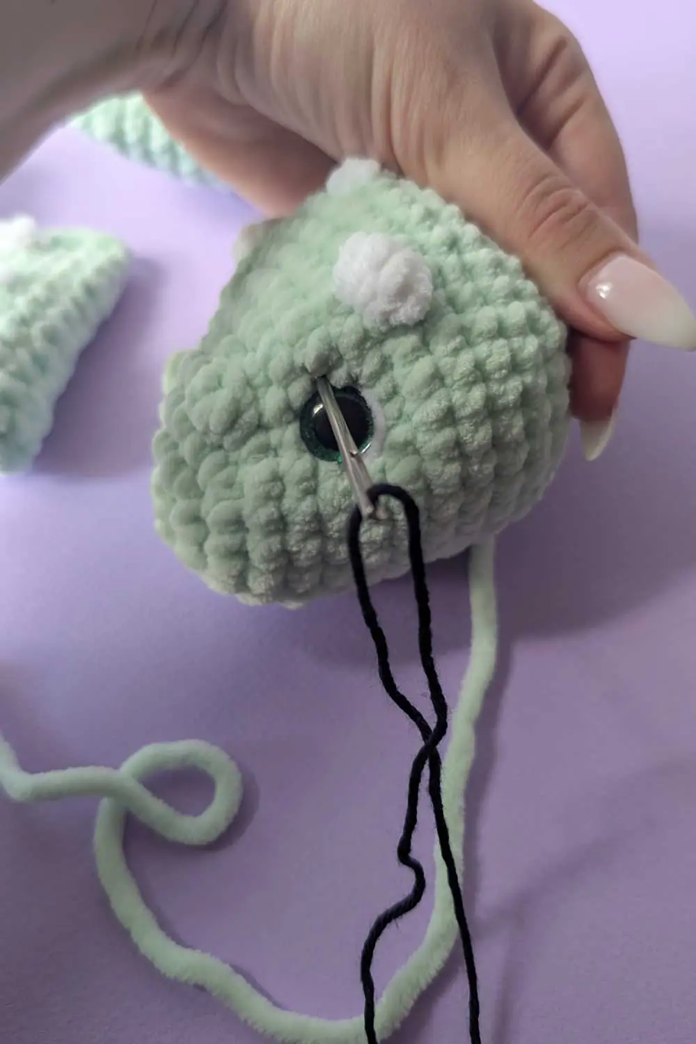 Crocheted dinosaur head in progress embroidery instructions