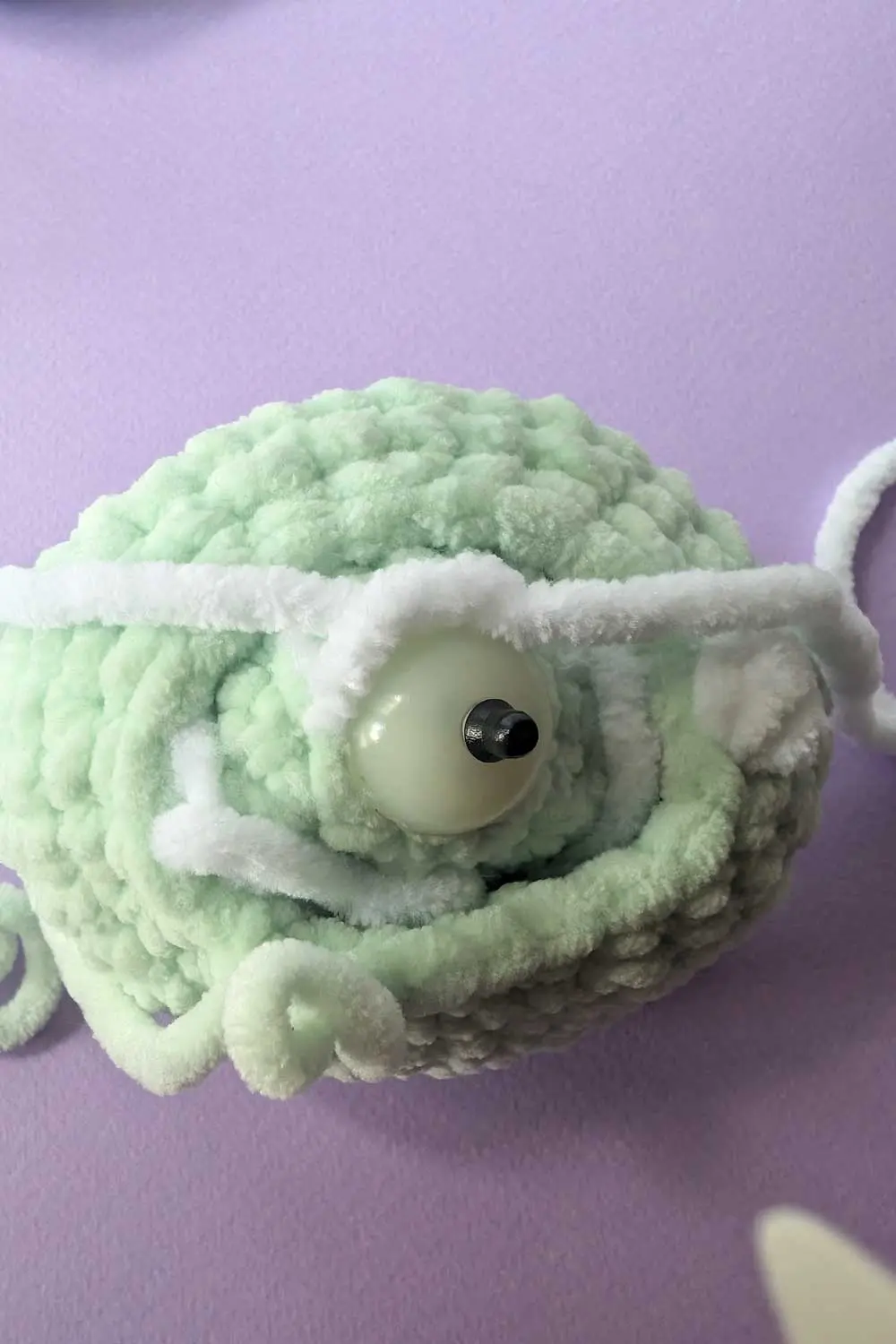 Crocheted dinosaur head in progress embroidery instructions