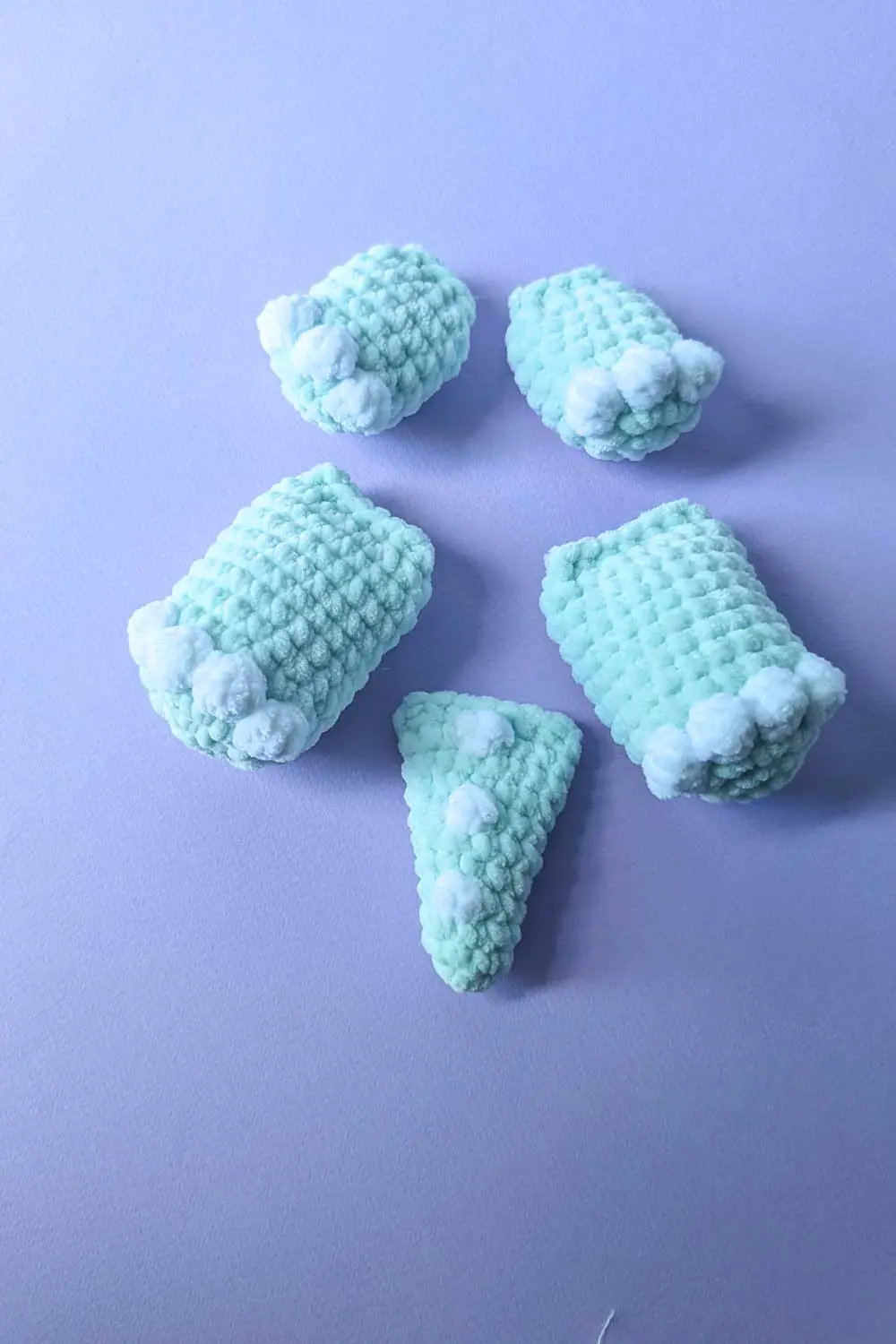 Crocheted dinosaur parts in mint green