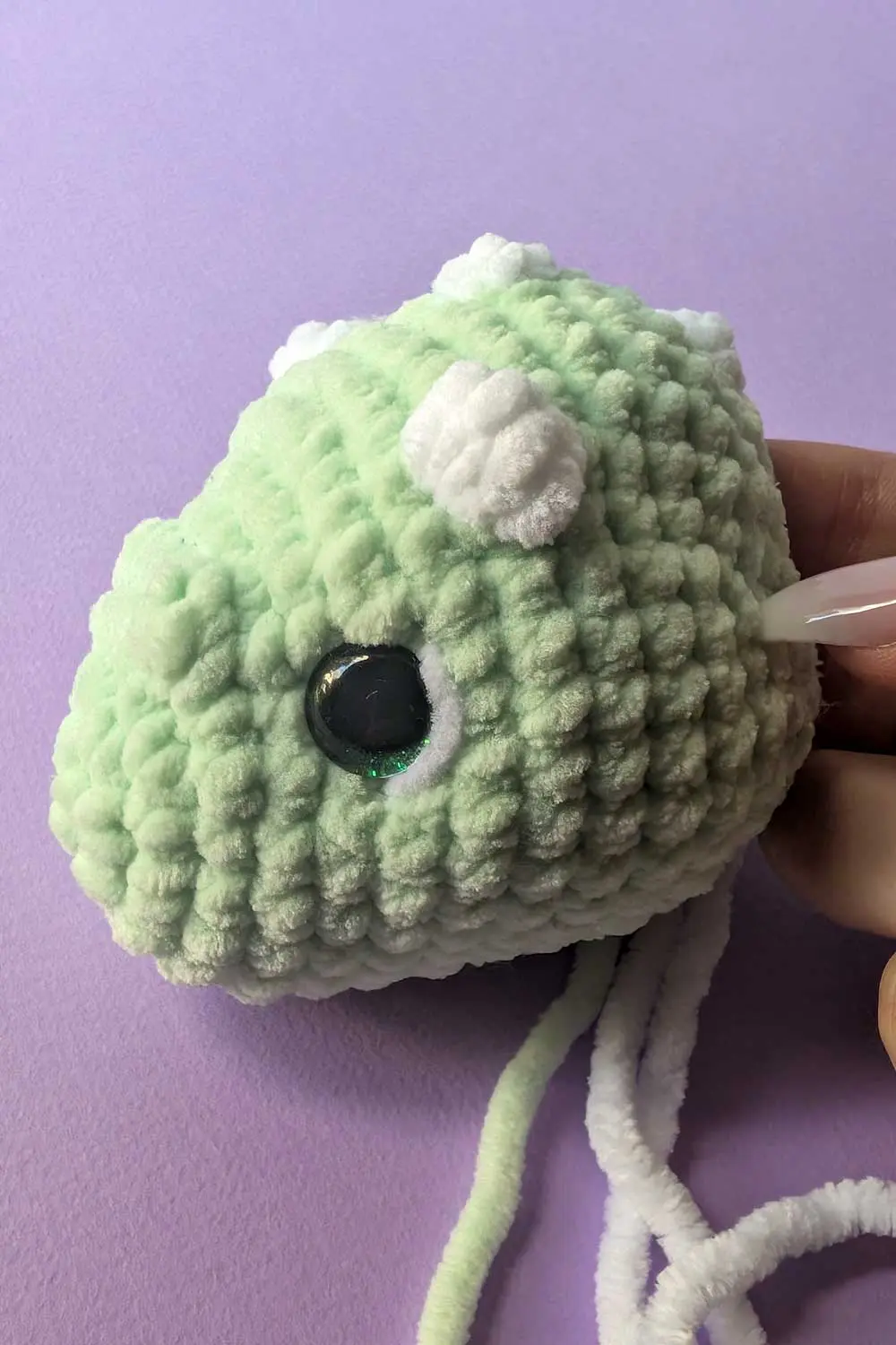 Crocheted dinosaur head in progress embroidery instructions