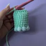 Crocheting a mint green plush piece with bobble stitches
