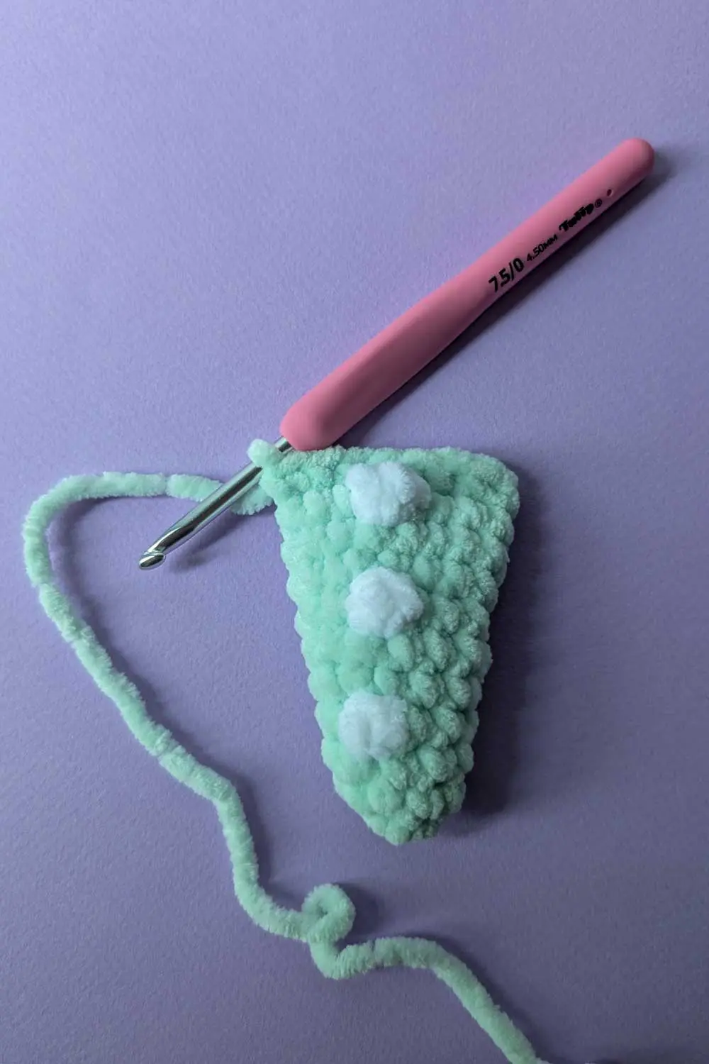 Mint green crochet dino tail with white crochet bobble stitches