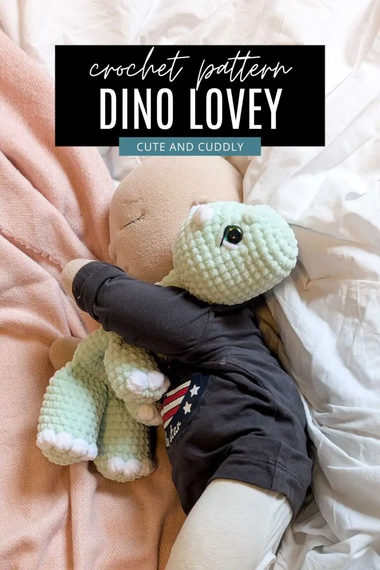 Feature image showing a crocheted dinosaur lovey made using the free pattern in the post, being hugged by a doll