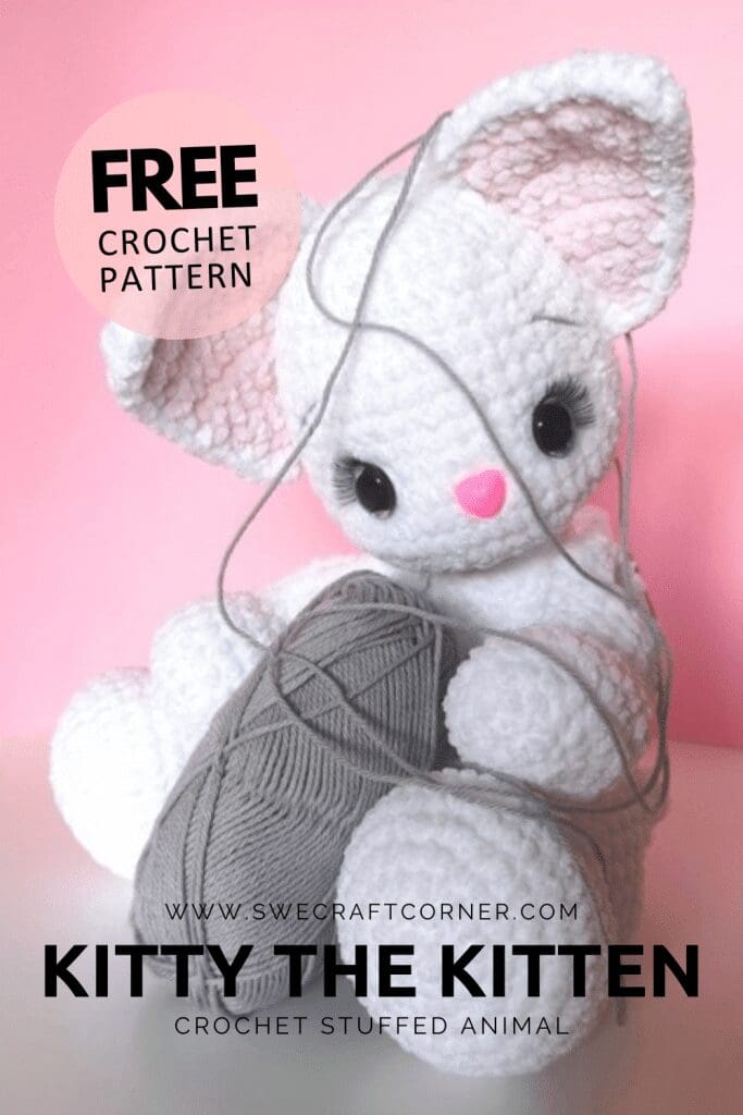 A crocheted white kitten plush with pink inner ears and nose, holding a ball of gray yarn. The crochet cat plushie is partially tangled in yarn. Text reads: FREE CROCHET PATTERN. KITTY THE KITTEN. Crochet stuffed animal.