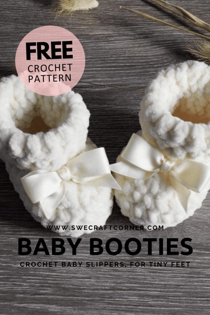 Two soft, white crochet newborn booties with white satin bows rest on a wooden surface. A text overlay advertises a free crochet pattern for baby slippers.