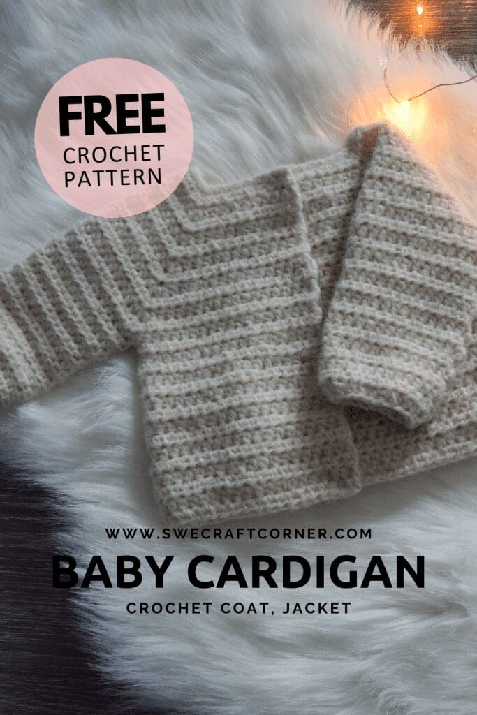 A cream-colored crochet baby cardigan is displayed on a fluffy white surface with string lights. Text overlay reads: Free baby cardigan crochet pattern, coat, jacket. www.swecraftcorner.com.