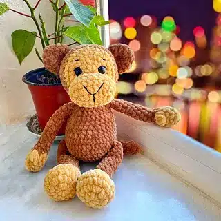 Crocheted monkey toy by window
