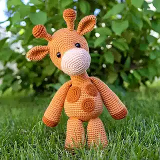 Crocheted orange giraffe toy standing