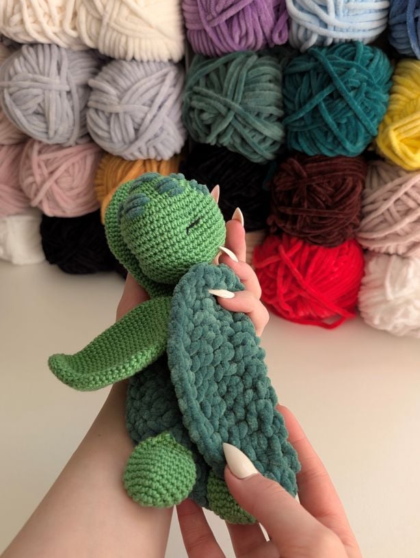 FREE Crochet patterns and crafts image of hands holding a turtle baby lovey free crochet pattern in the article