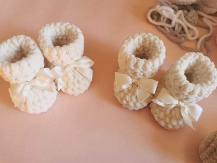 Baby crochet accessories pattern category cover with baby booties crocheted in chenille yarn featuring satin bows on soft background