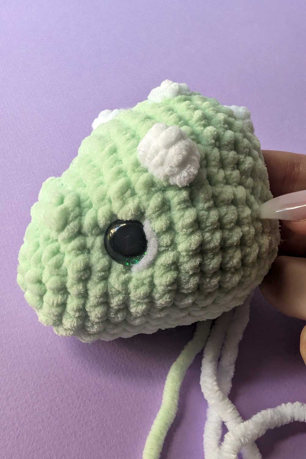 Crocheted dinosaur head in progress embroidery instructions