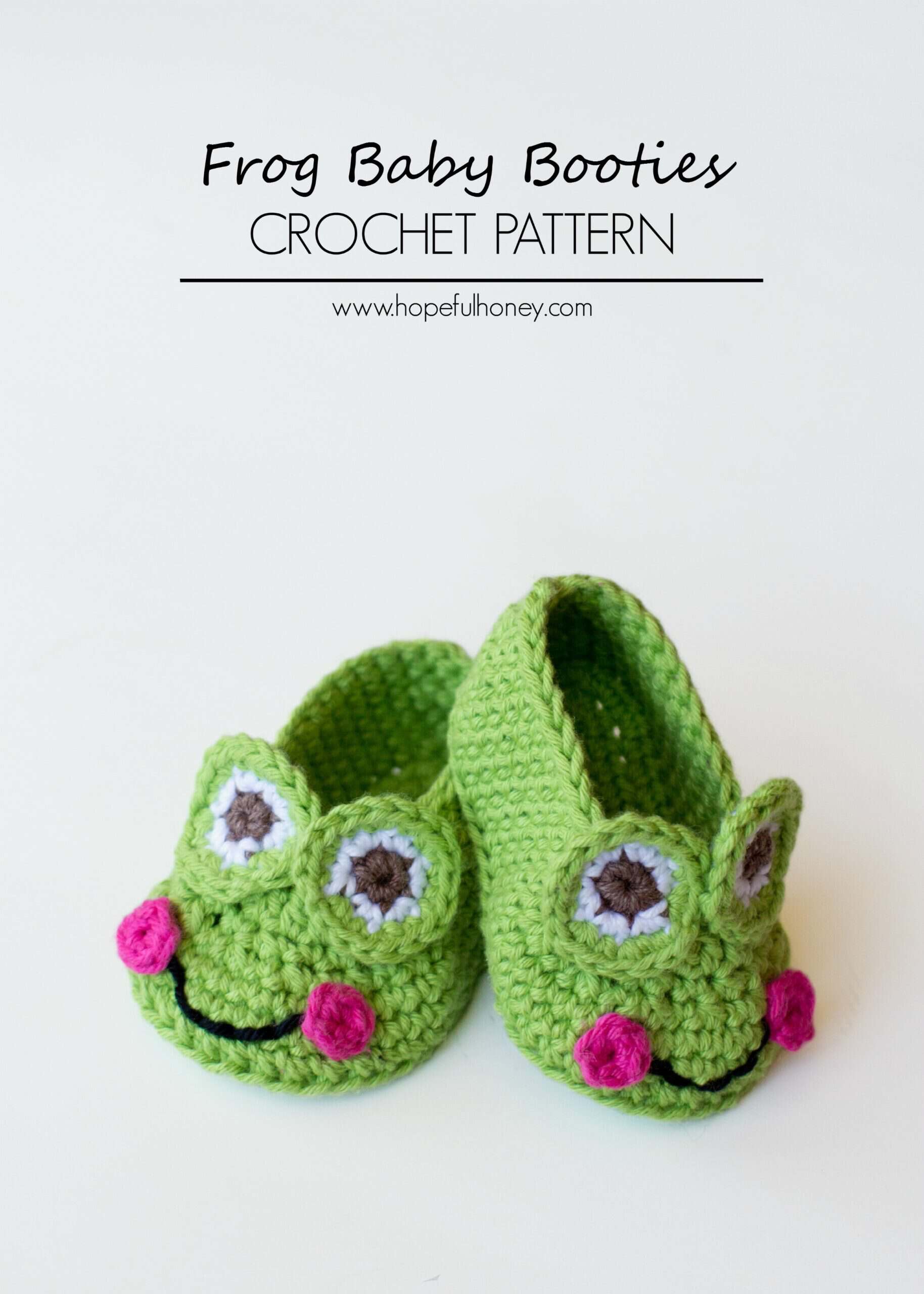 Two green crocheted baby booties designed to look like frogs, with white and brown eyes, pink cheeks, and a black smile. Text above reads Frog Baby Booties CROCHET PATTERN.