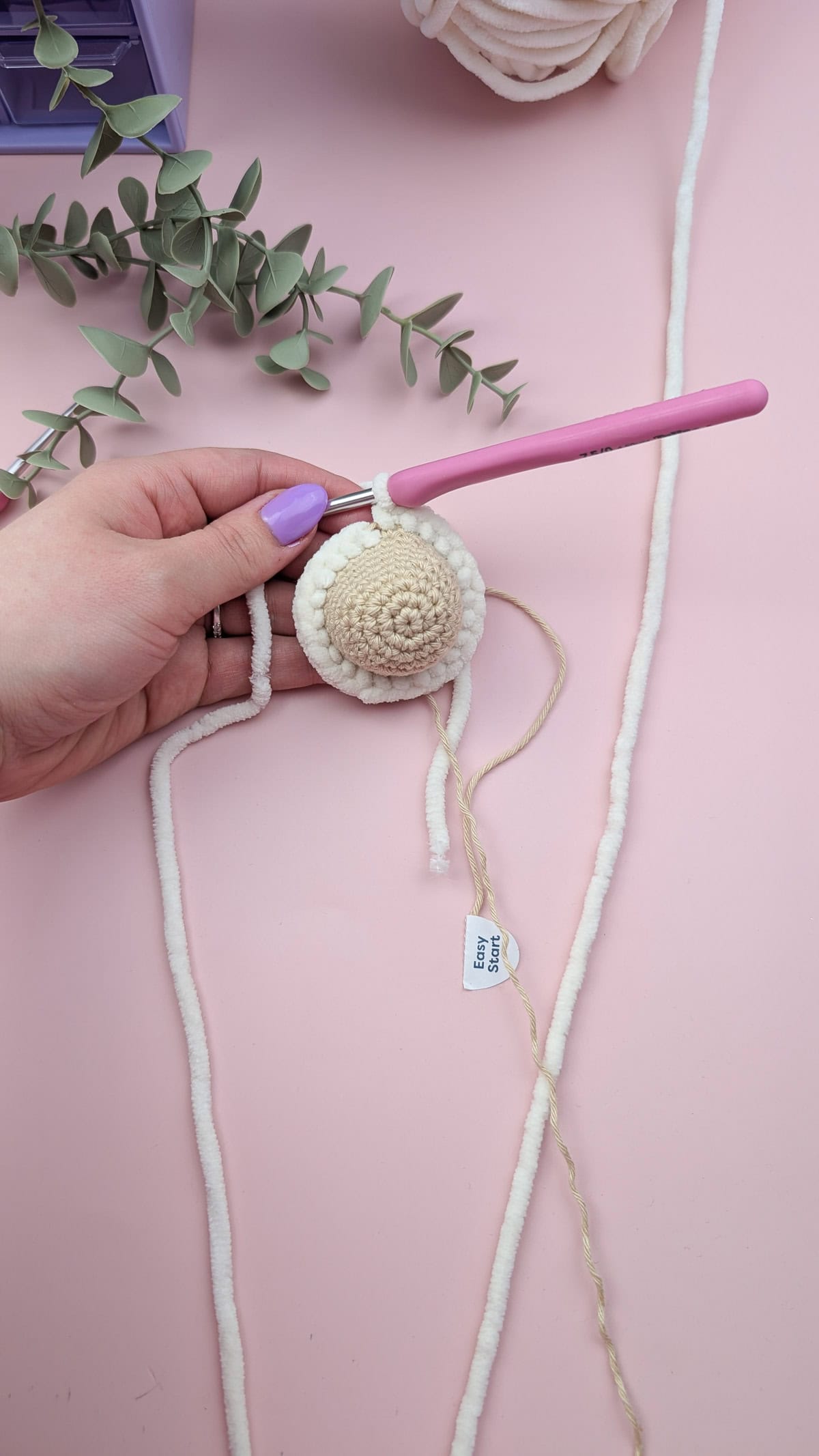 crochet lamb lovey head in progress on pink background